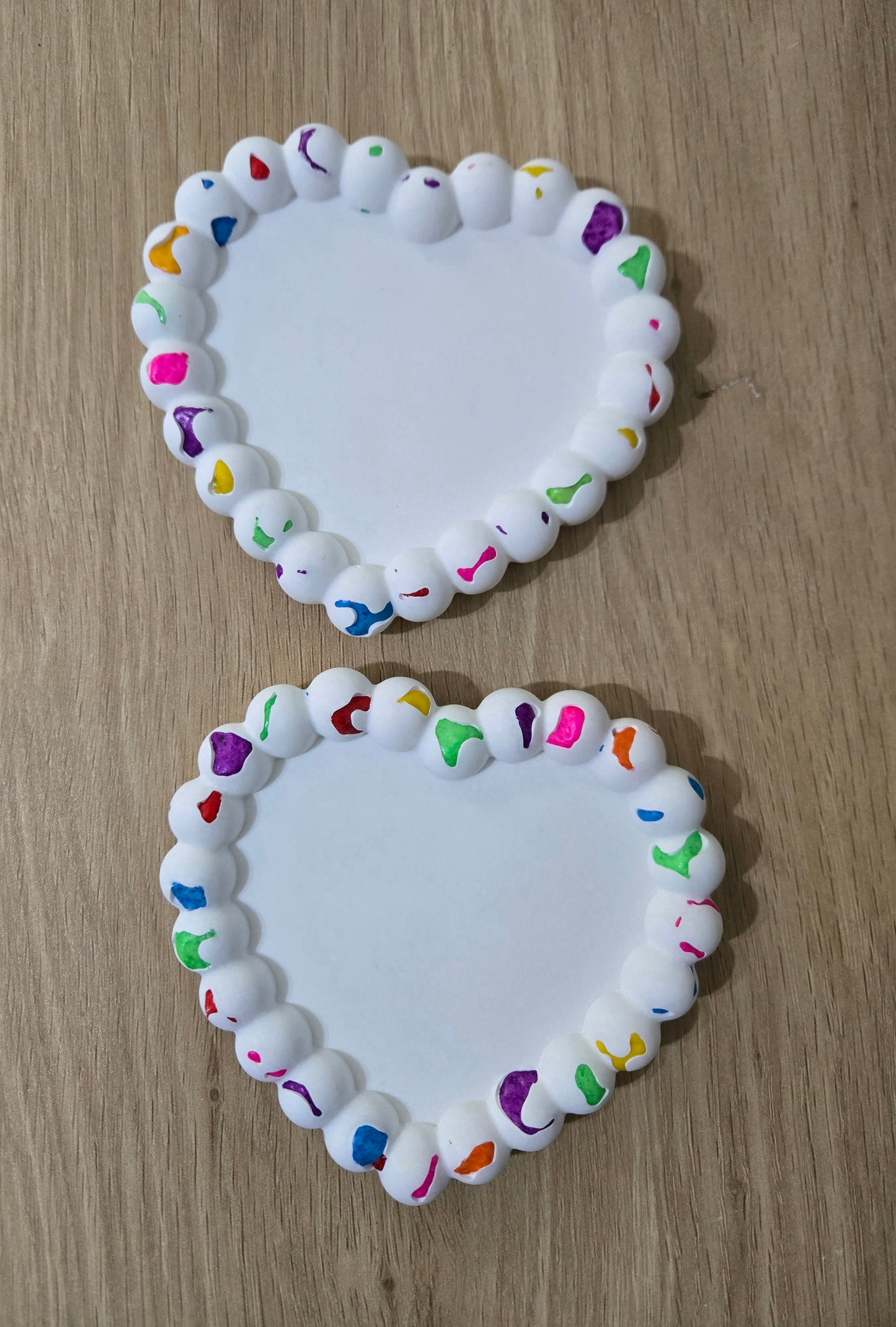 Heart shaped color stone coaster on a wooden table