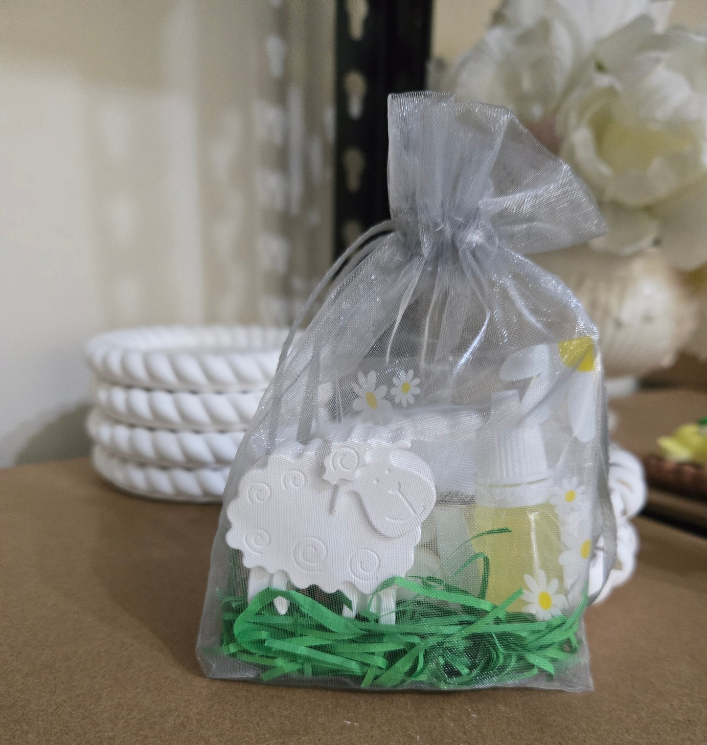 Gift bag with a sheep air freshner and greenery on a table little light & co