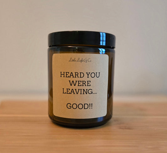 Candle jar with a humorous label on a wooden surface