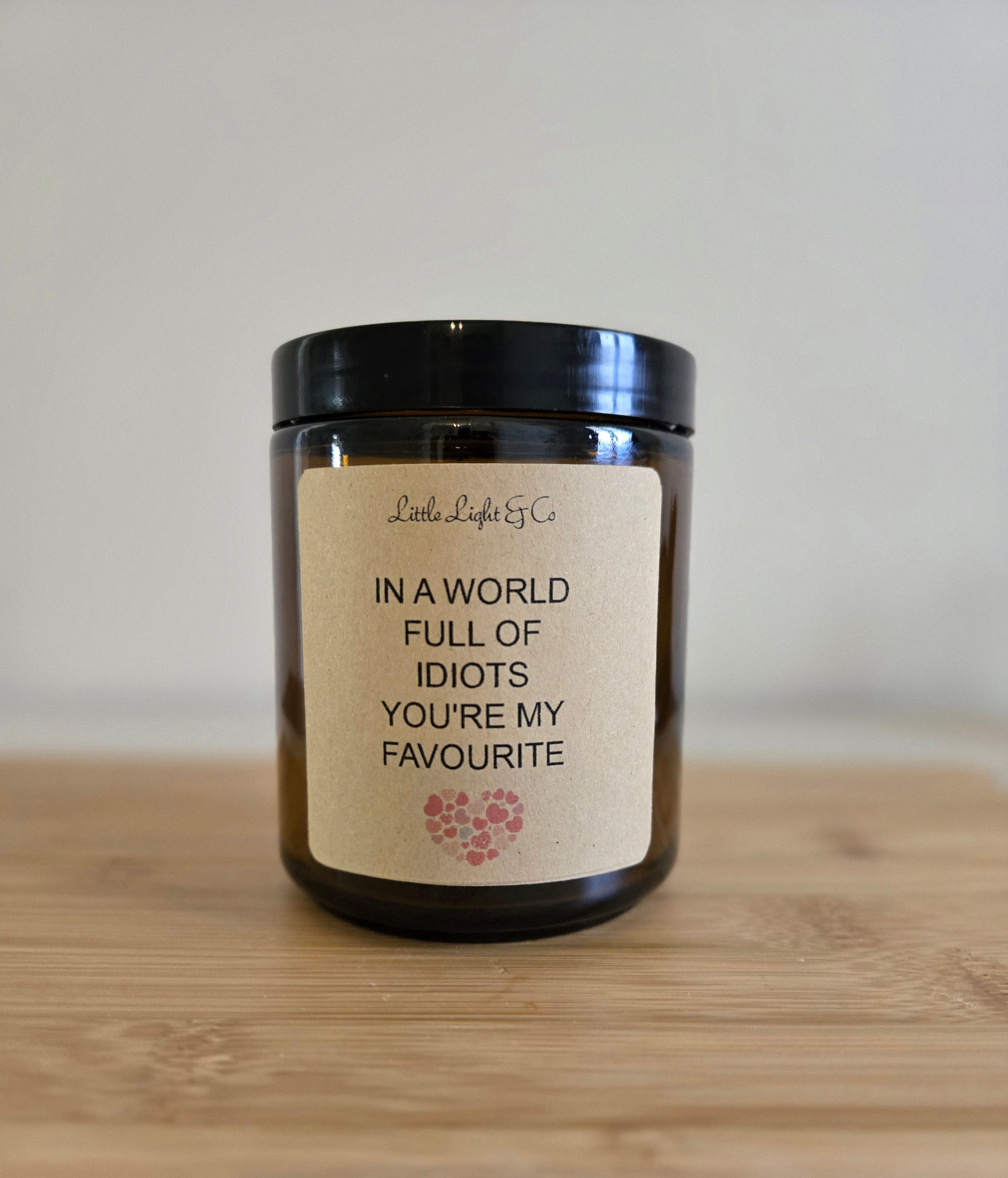 Candle with a label on a wooden surface