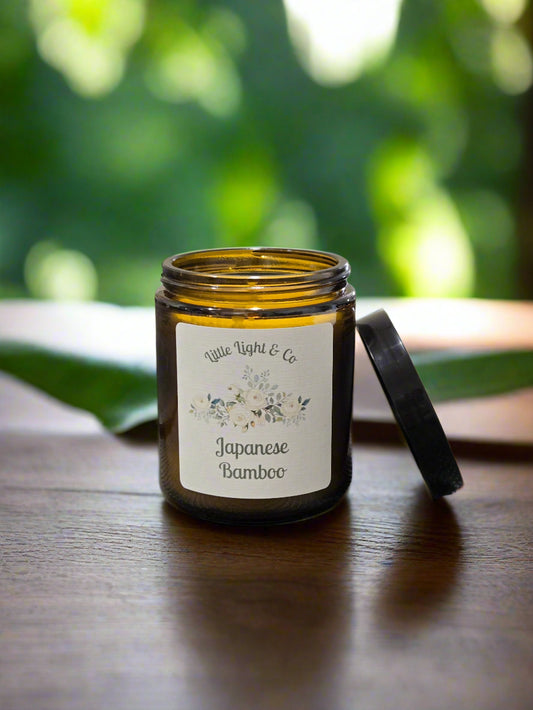 Candle jar labeled 'Japanese Bamboo' by Little Light Co on a textured surface.