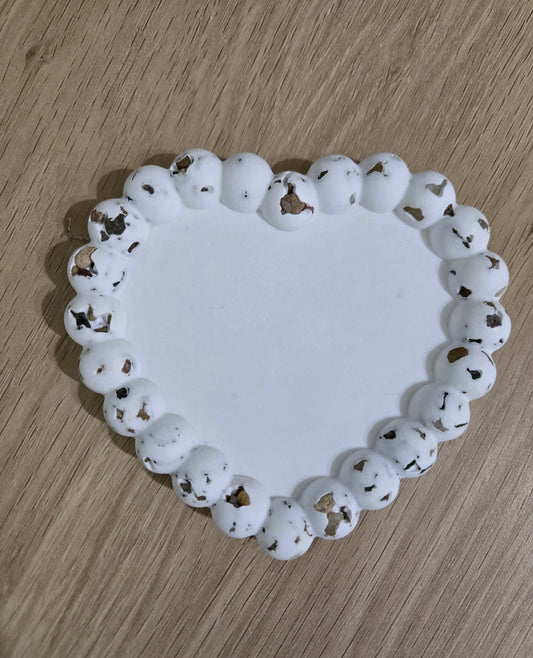 Natural stone heart shaped coaster on a wooden surface.