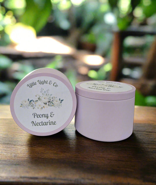 Purple candle tin with 'Little Light & Co' peony nectarine fragrance