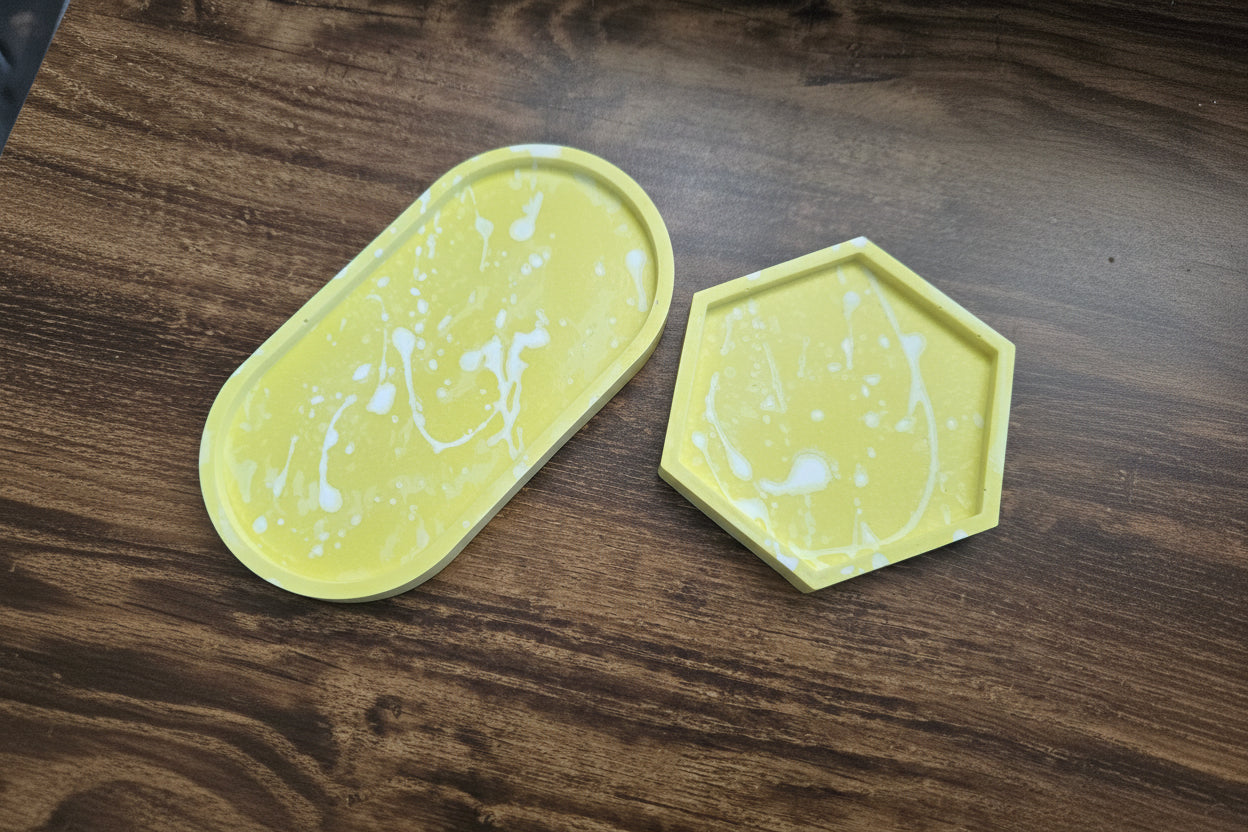 Two yellow marbled coasters on a wooden surface